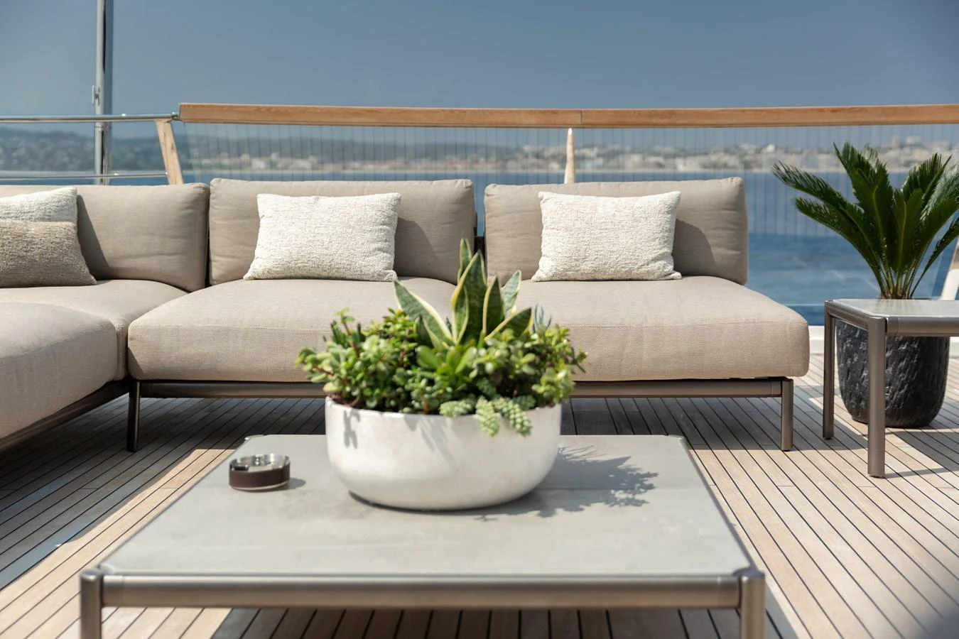 The aft deck features a stylish seating area with plush cushions and a central coffee table adorned with a plant arrangement. aboard NANGARA Yacht for Sale