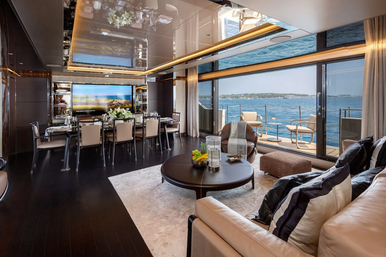 The luxurious salon features elegant furnishings and expansive windows with stunning ocean views. aboard NANGARA Yacht for Sale