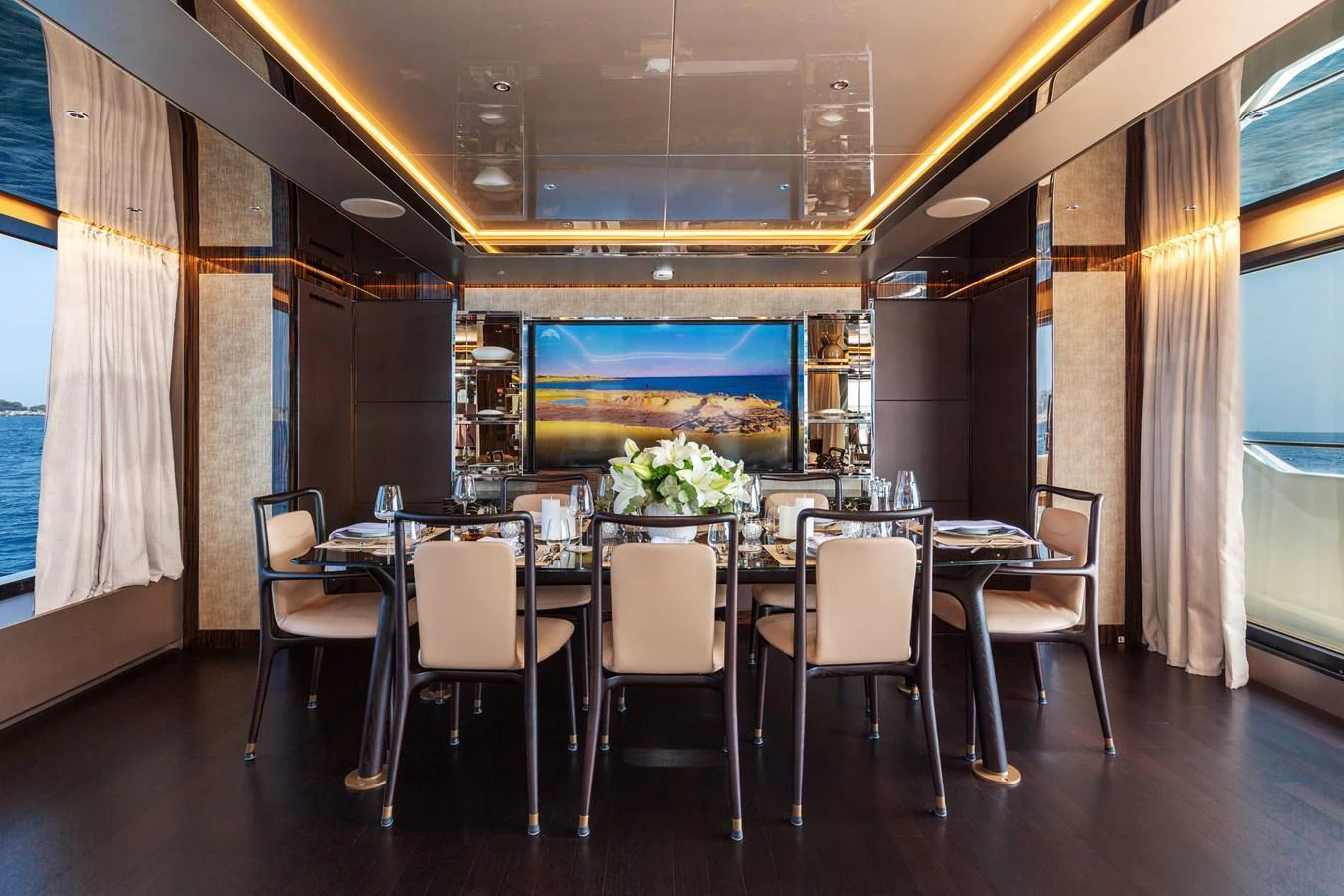 The yacht's dining area features elegant seating and a large screen for entertainment. aboard NANGARA Yacht for Sale