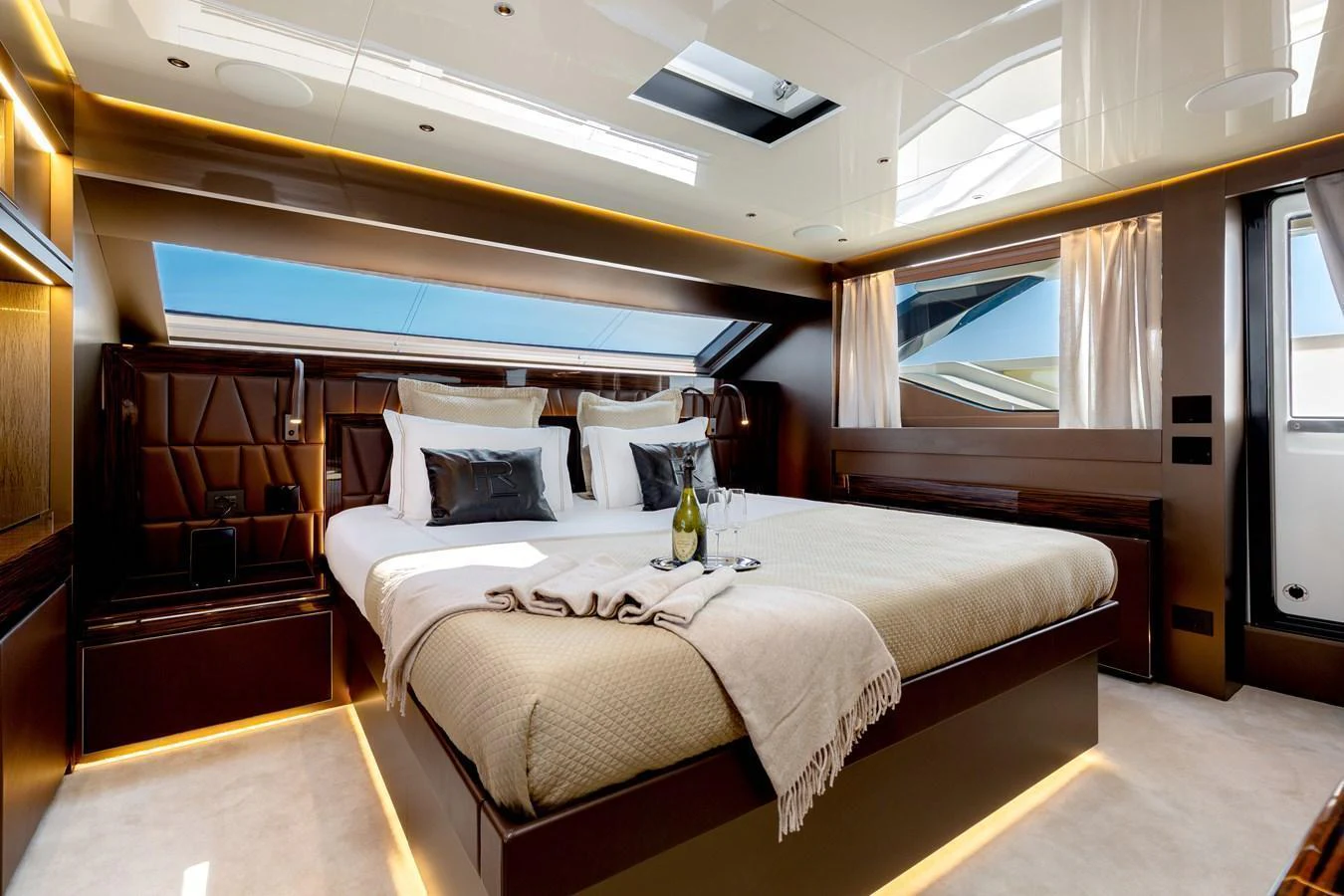 The master stateroom features a luxurious bed with elegant bedding and ample natural light from large windows. aboard NANGARA Yacht for Sale