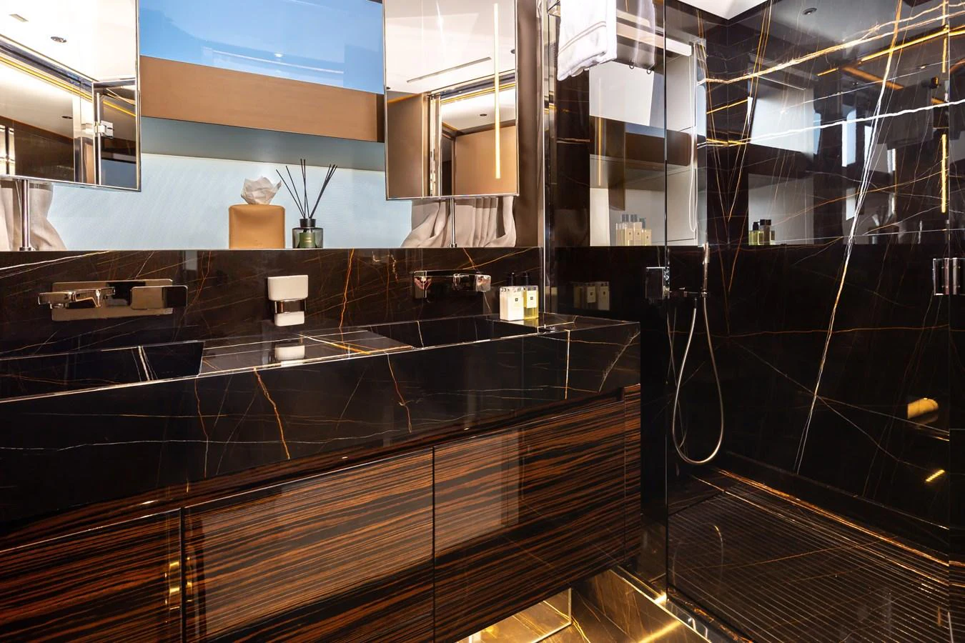 The bathroom features luxurious dark marble finishes with modern fixtures and ample lighting. aboard NANGARA Yacht for Sale