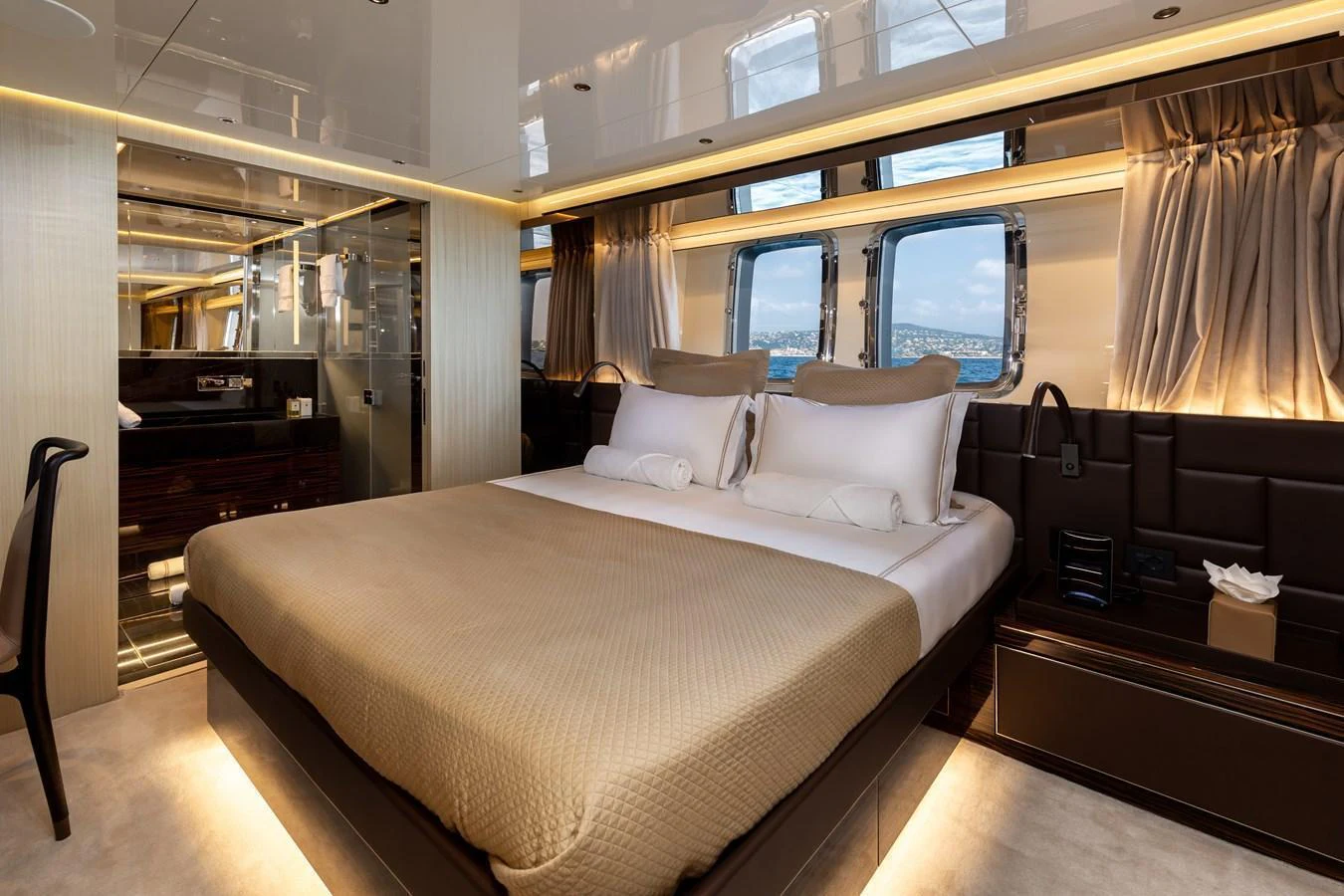 The master stateroom features a luxurious bed with elegant lighting and panoramic windows. aboard NANGARA Yacht for Sale