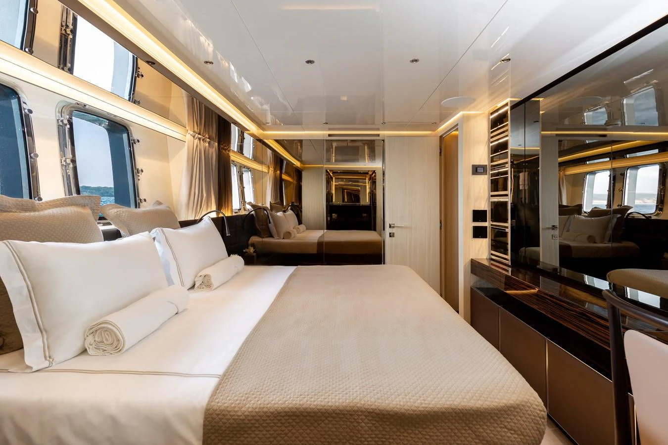 The master stateroom features a luxurious bed with elegant bedding and ample natural light from large windows. aboard NANGARA Yacht for Sale