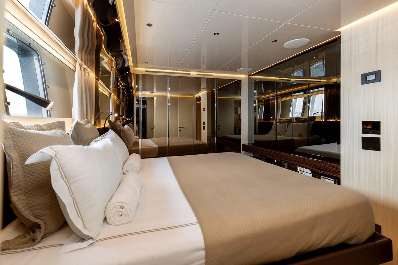 The stateroom features a luxurious bed with elegant linens and ample natural light from the windows. aboard NANGARA Yacht for Sale