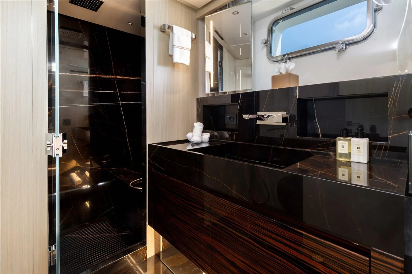 The yacht's bathroom features a sleek, modern design with dark marble accents and high-end fixtures. aboard NANGARA Yacht for Sale