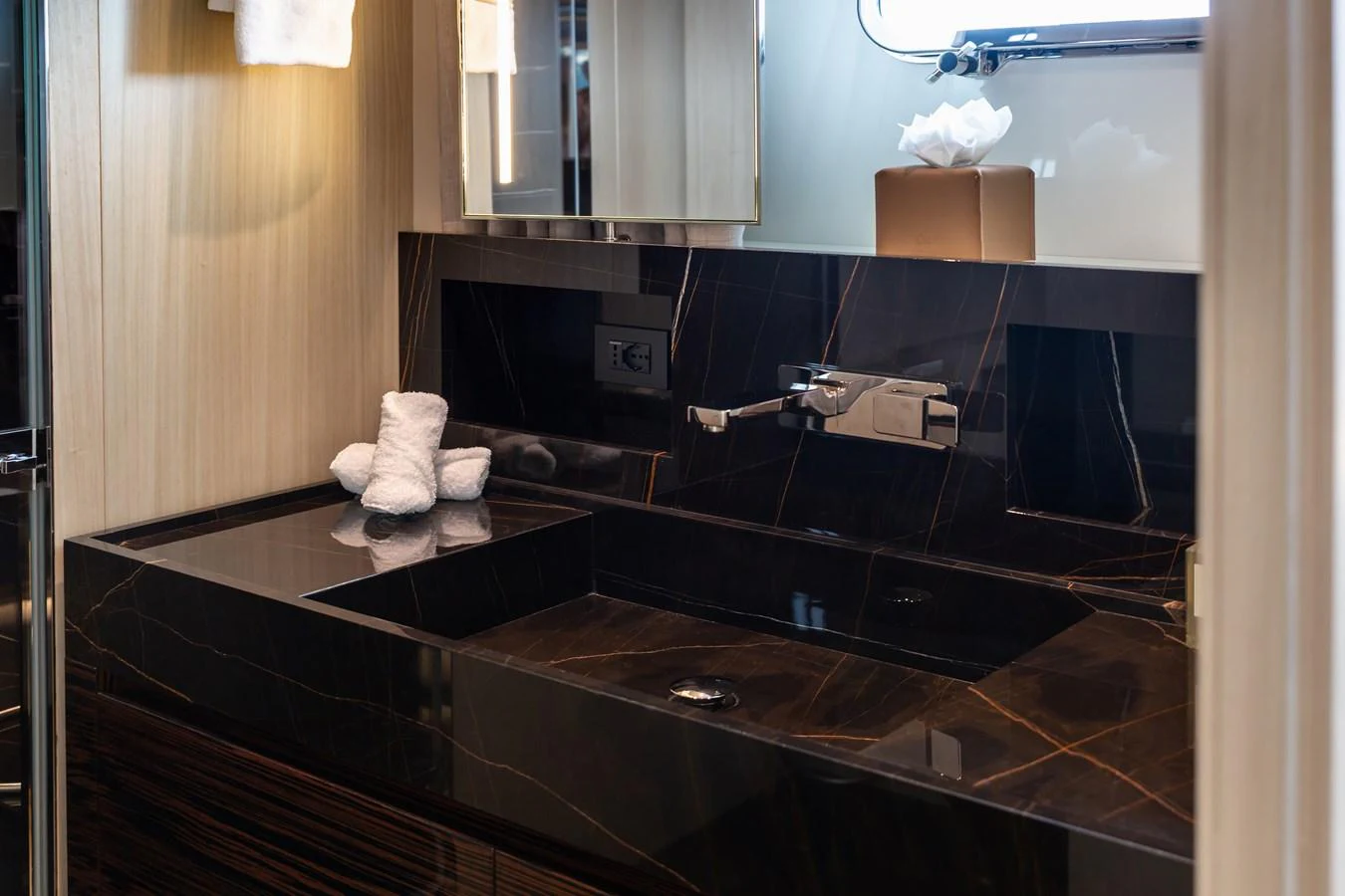 The yacht's bathroom features a sleek black marble sink and modern fixtures. aboard NANGARA Yacht for Sale
