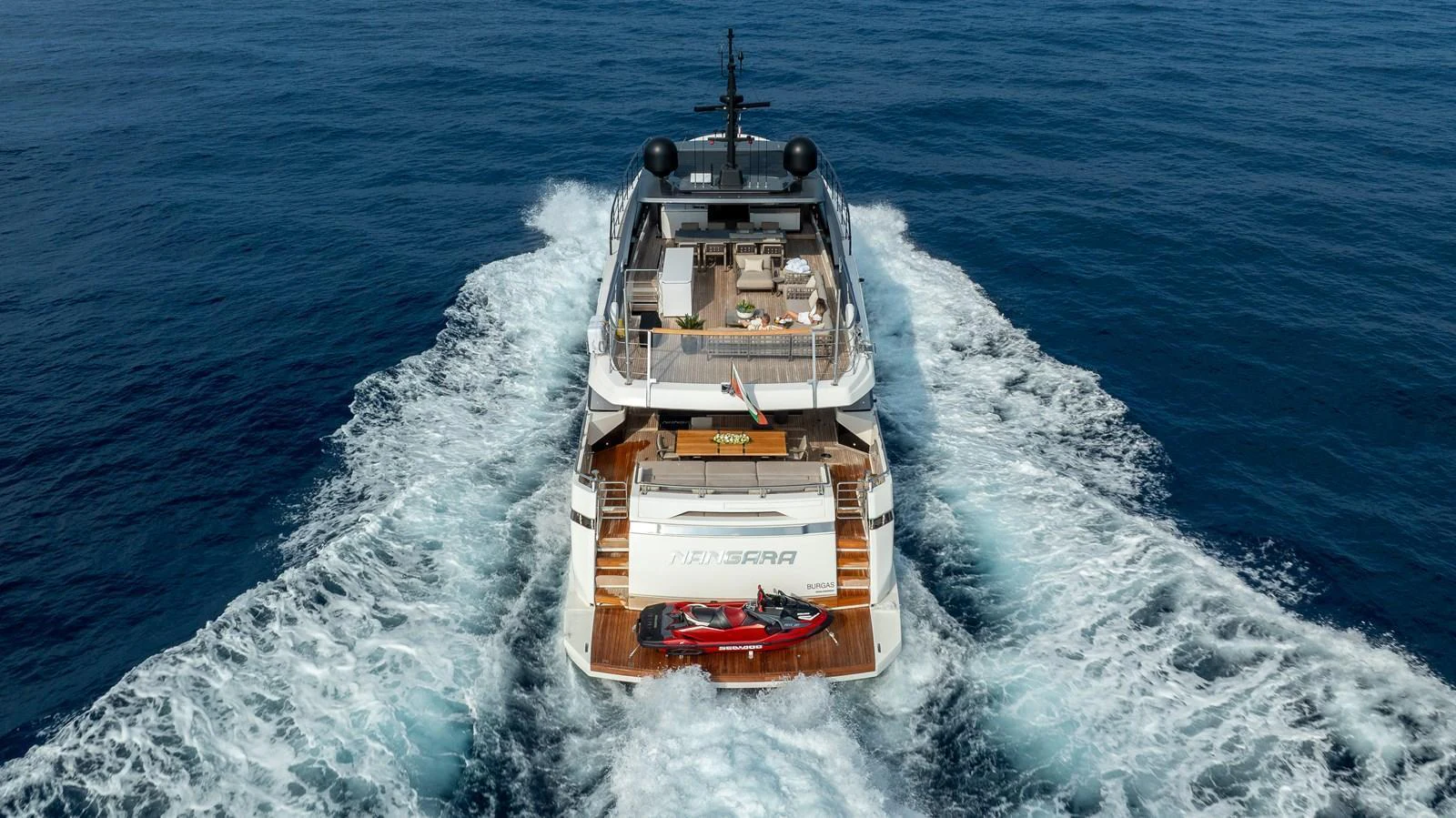 A luxurious yacht cruising through the open sea, showcasing its spacious aft deck and sleek design. aboard NANGARA Yacht for Sale