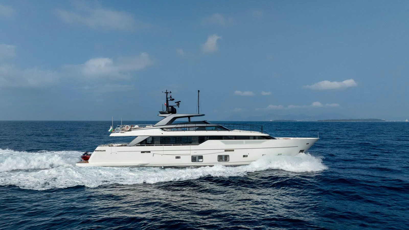 A sleek and modern yacht cruises through the open sea under a clear blue sky. aboard NANGARA Yacht for Sale