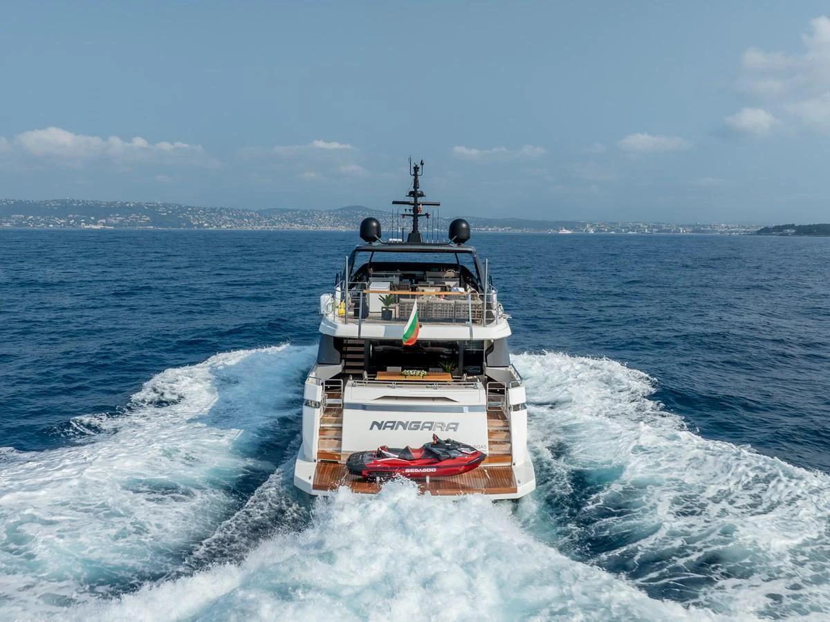A luxurious yacht cruises through the open sea, leaving a trail of white waves behind. aboard NANGARA Yacht for Sale