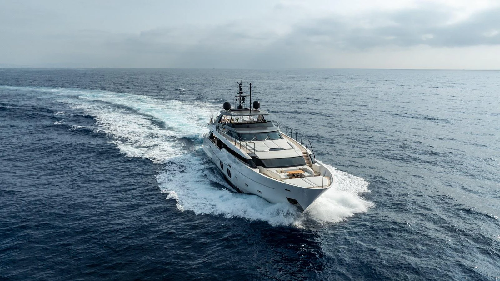 A sleek yacht cruises through open waters, leaving a trail of white foam behind. aboard NANGARA Yacht for Sale