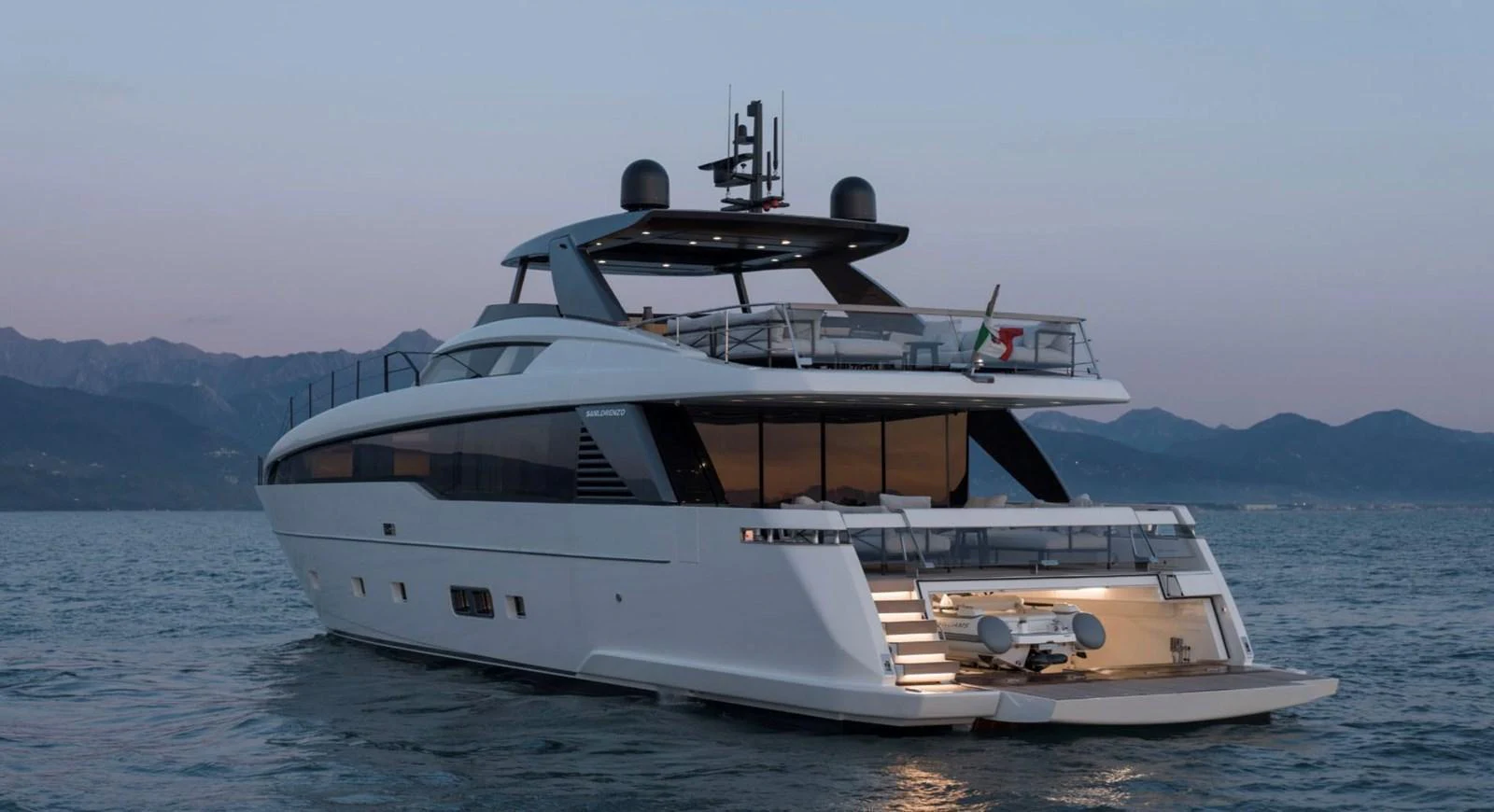 A sleek and modern yacht cruising on calm waters at dusk, showcasing its elegant design and spacious deck areas. aboard SL86A Yacht for Sale
