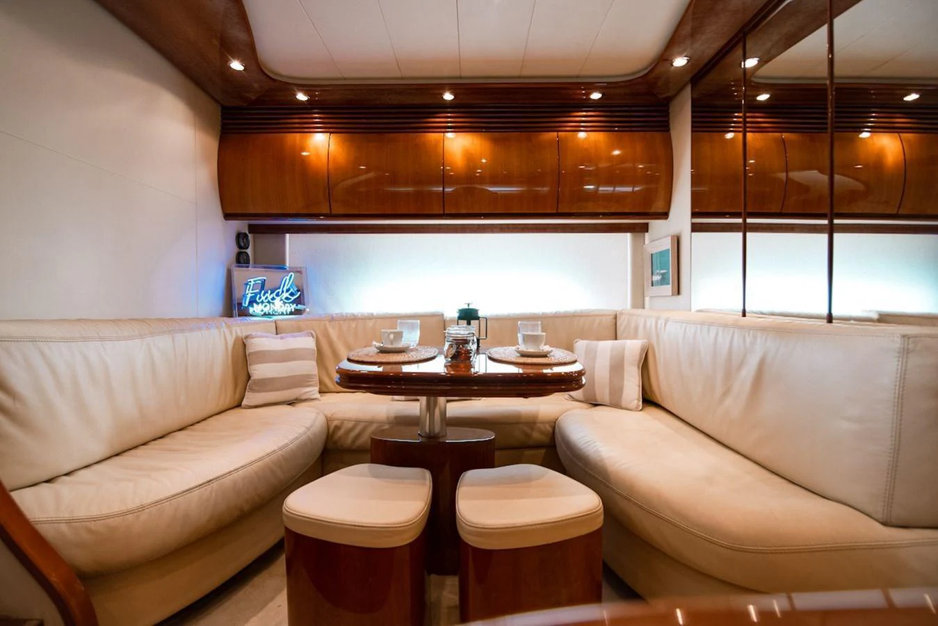 The salon features a cozy seating area with a wooden table and plush cushions. aboard AXION Yacht for Sale