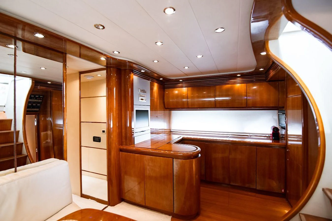 The yacht's galley features polished wood cabinetry and modern appliances, creating a warm and inviting space. aboard AXION Yacht for Sale