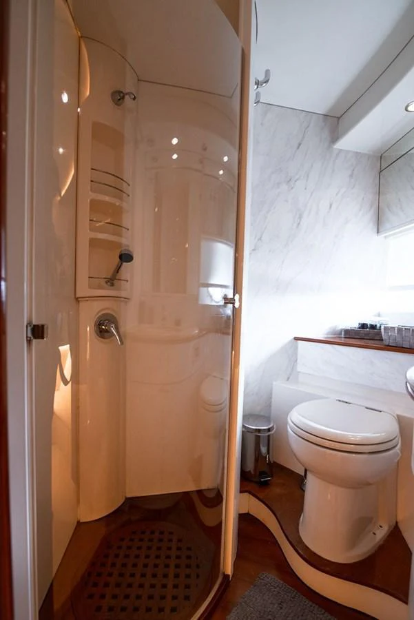 A sleek and modern yacht bathroom featuring a curved shower and elegant fixtures. aboard AXION Yacht for Sale
