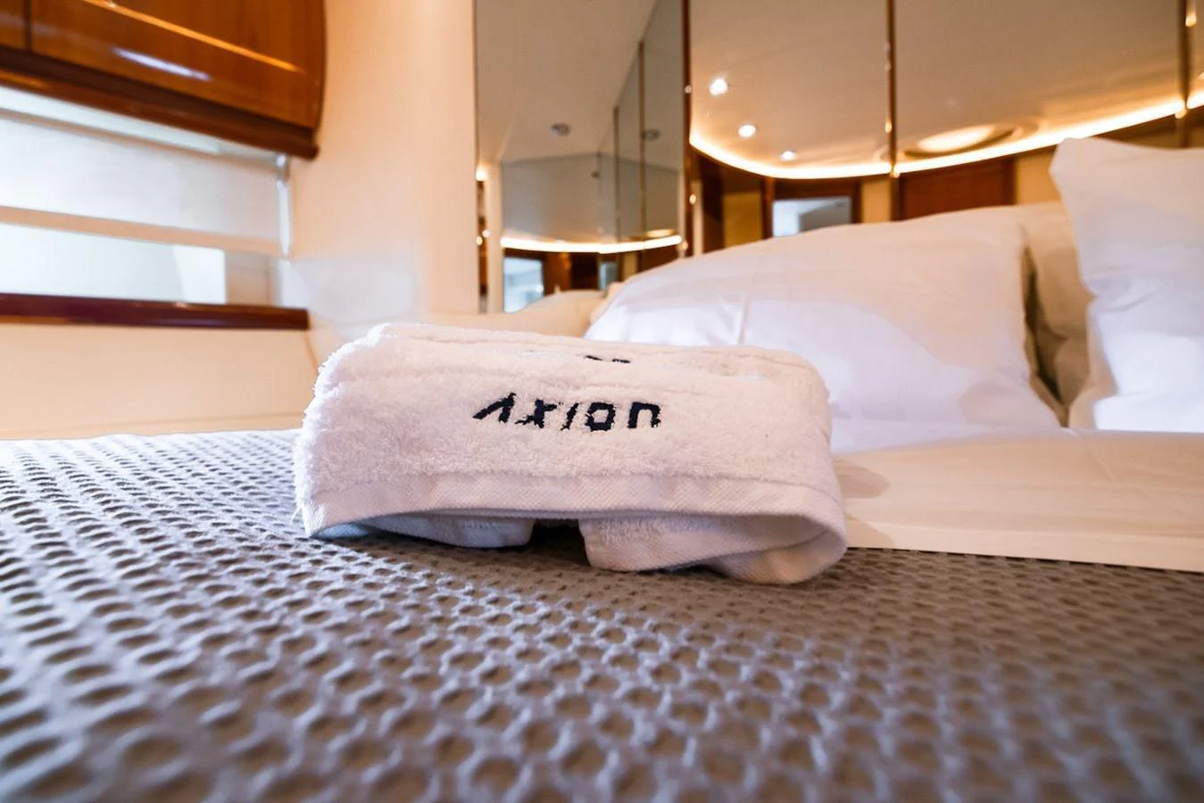 A cozy stateroom with plush bedding and a neatly folded towel. aboard AXION Yacht for Sale