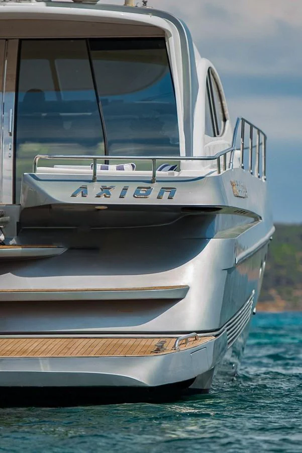 The yacht's sleek and modern stern is showcased as it sits gracefully on the water. aboard AXION Yacht for Sale