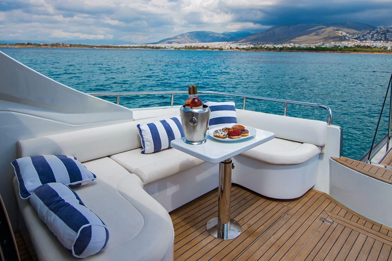 The aft deck features a cozy seating area with a table set for refreshments, offering a perfect spot to relax and enjoy the view. aboard AXION Yacht for Sale