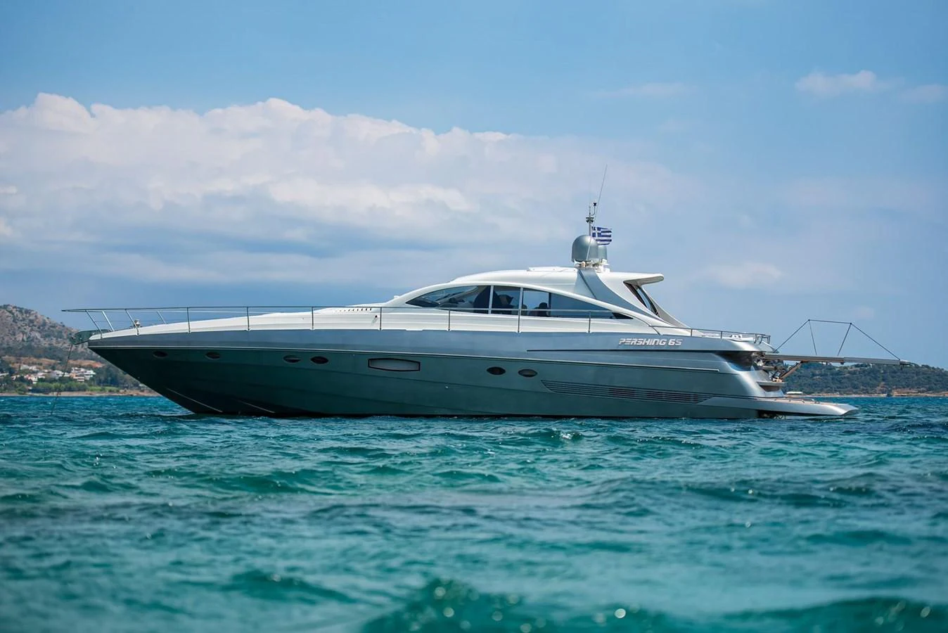 A sleek yacht glides gracefully on the water under a clear sky. aboard AXION Yacht for Sale