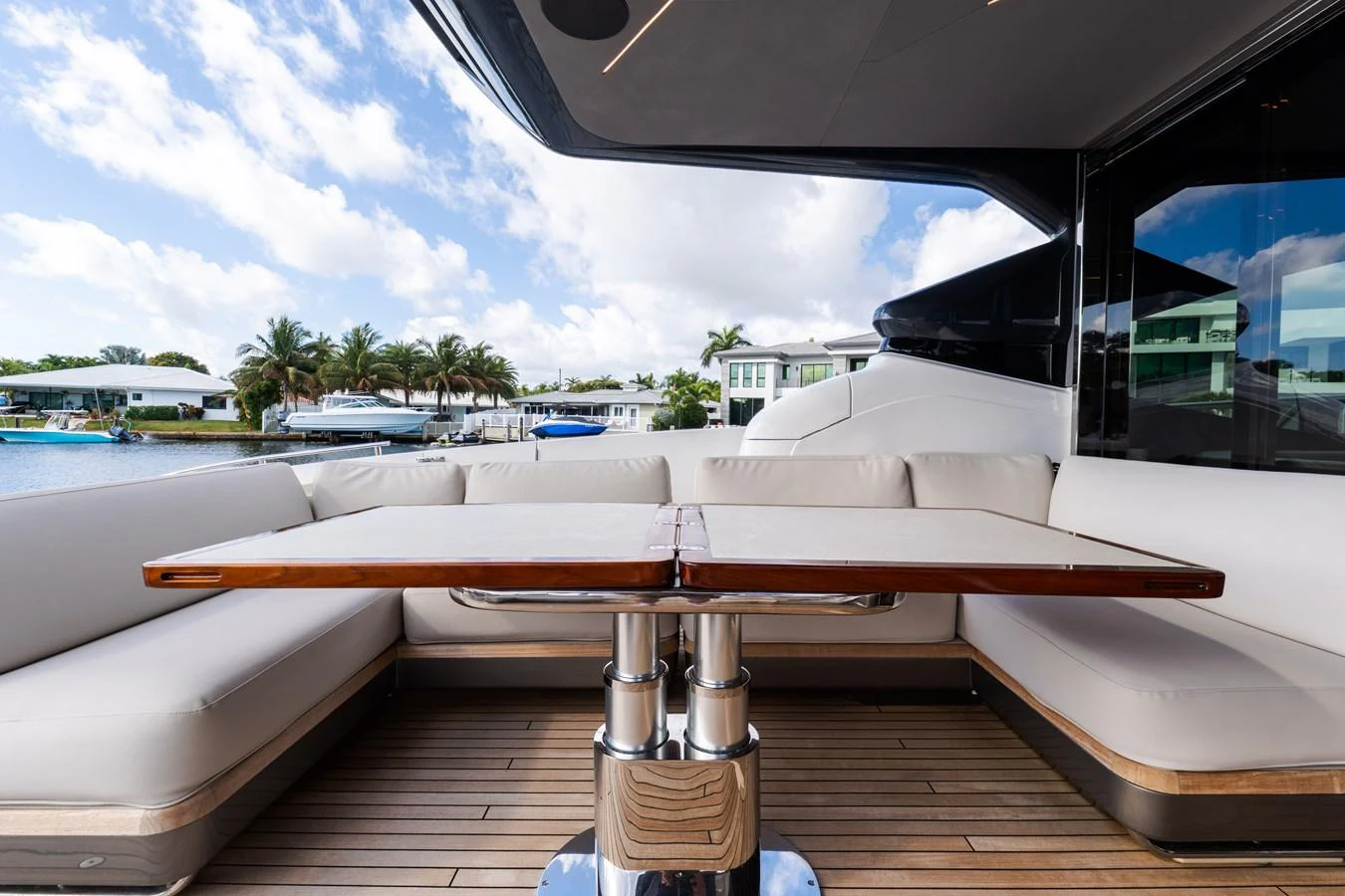 The aft deck offers a spacious seating area with a polished wooden table, perfect for alfresco dining. aboard NAUTI NATALIE Yacht for Sale