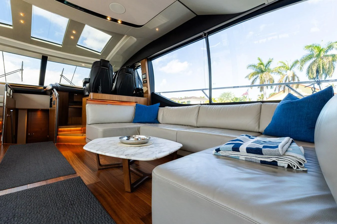The salon features a luxurious seating area with a modern design and panoramic windows. aboard NAUTI NATALIE Yacht for Sale