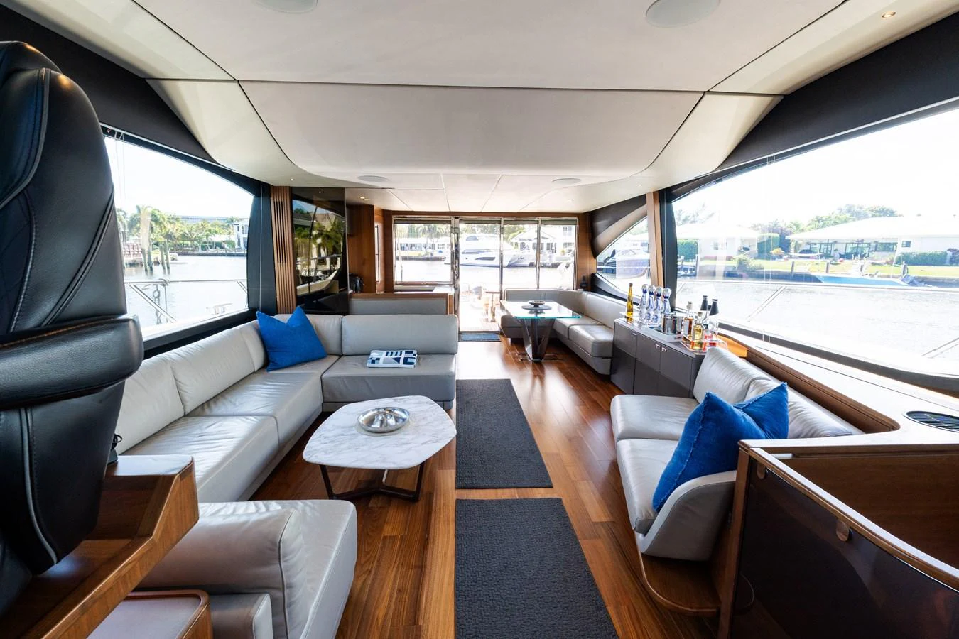 The yacht's salon features luxurious seating, a stylish coffee table, and expansive windows for panoramic views. aboard NAUTI NATALIE Yacht for Sale