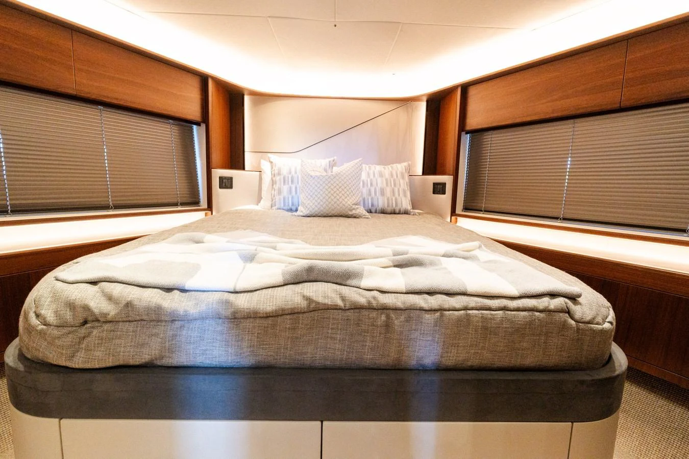 The stateroom features a luxurious bed with plush bedding and ample natural light from the surrounding windows. aboard NAUTI NATALIE Yacht for Sale