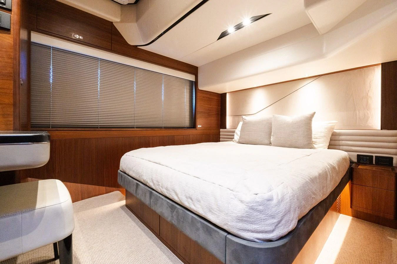 The stateroom features a plush bed with elegant wood paneling and modern lighting. aboard NAUTI NATALIE Yacht for Sale