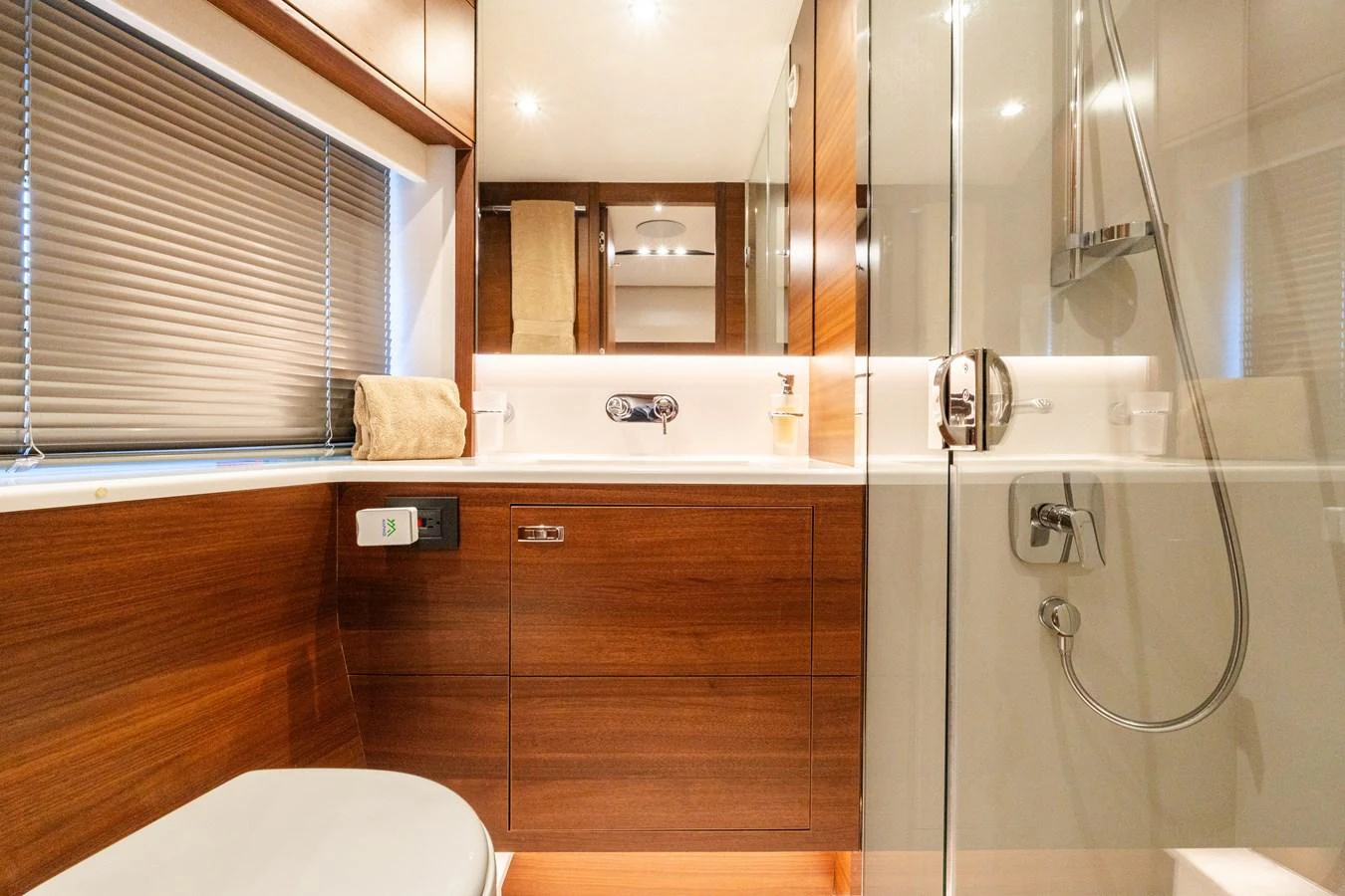 The yacht's bathroom features sleek wooden cabinetry and modern fixtures, creating a warm and inviting space. aboard NAUTI NATALIE Yacht for Sale