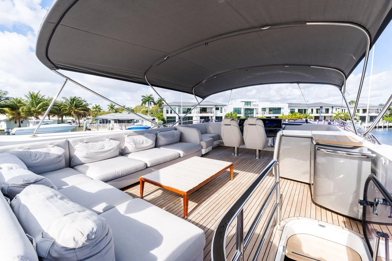 The flybridge offers a spacious and luxurious outdoor lounging area with ample seating and a shaded canopy. aboard NAUTI NATALIE Yacht for Sale