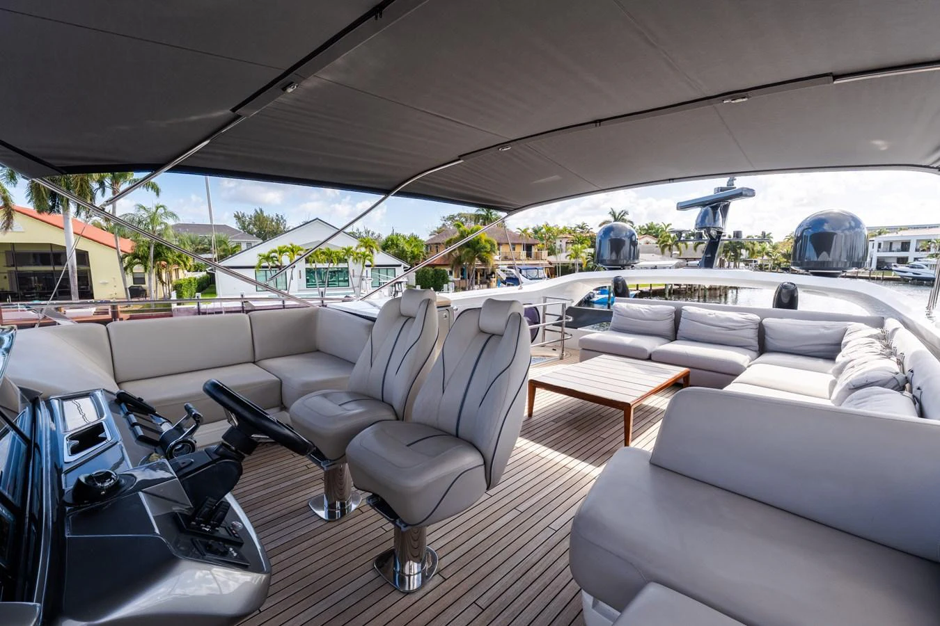 The flybridge offers a spacious and luxurious outdoor seating area with plush furnishings and a helm station. aboard NAUTI NATALIE Yacht for Sale
