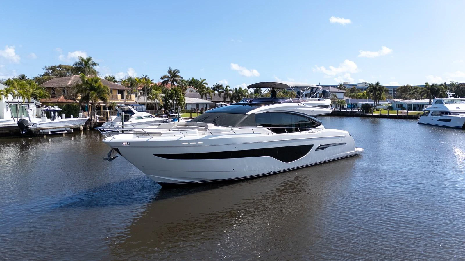 A sleek and modern yacht glides gracefully on calm waters near a marina. aboard NAUTI NATALIE Yacht for Sale
