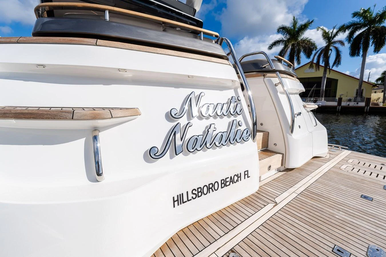 The aft deck of the yacht showcases elegant wooden decking and polished stainless steel accents. aboard NAUTI NATALIE Yacht for Sale