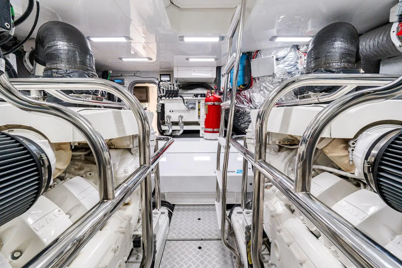 The image showcases a pristine engine room with well-maintained machinery and polished metal railings. aboard NAUTI NATALIE Yacht for Sale
