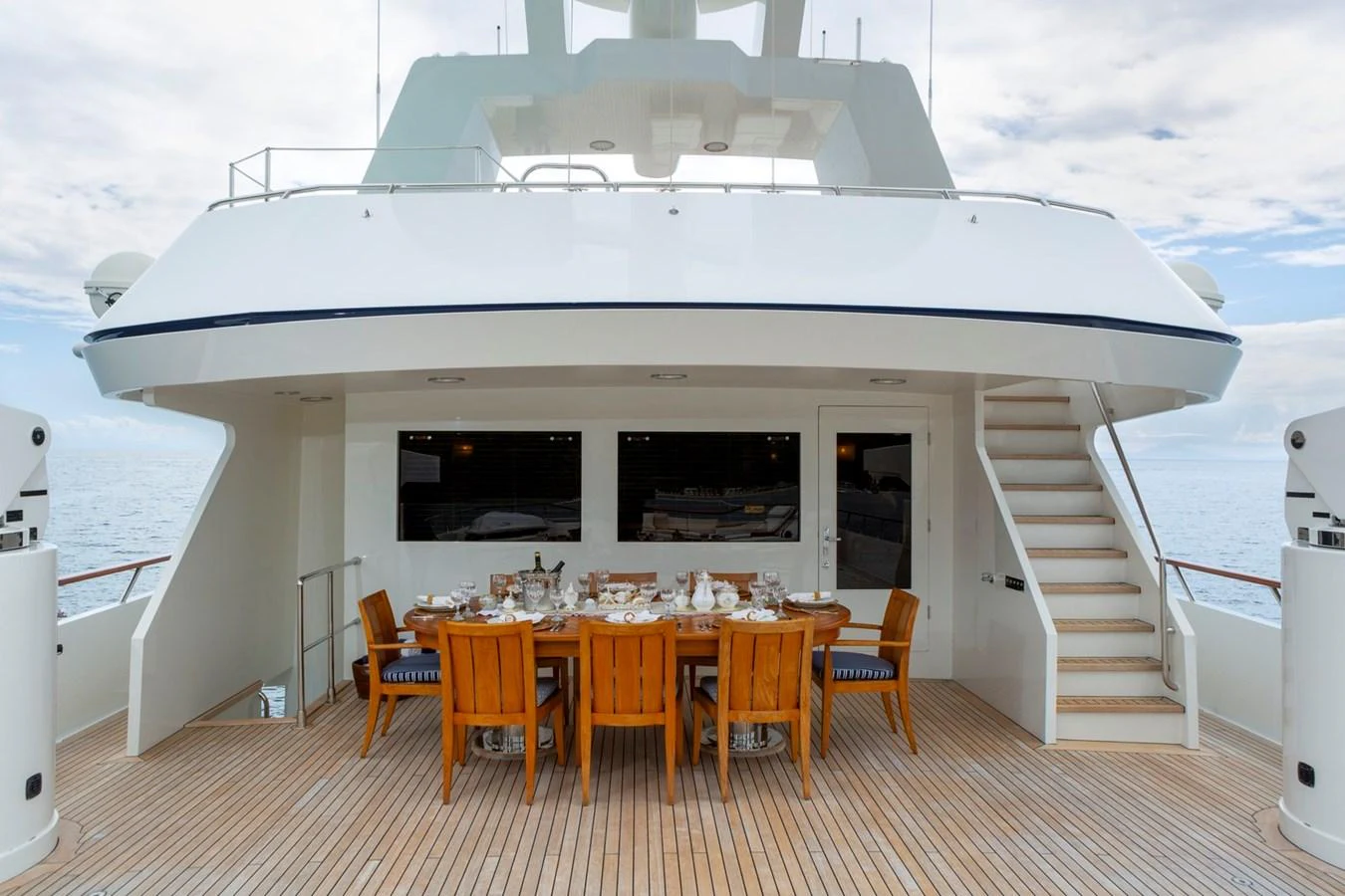 The aft deck features an elegant dining area with a beautifully set table, perfect for alfresco meals. aboard CONSTANCE Yacht for Sale