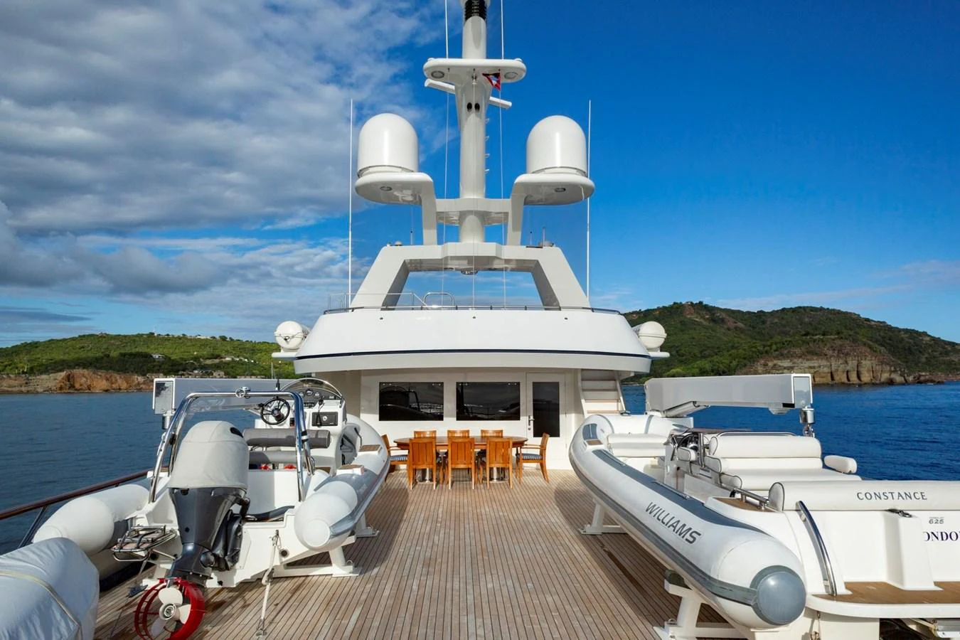 The aft deck features ample seating and dining space, complemented by two tenders for easy access to the shore. aboard CONSTANCE Yacht for Sale
