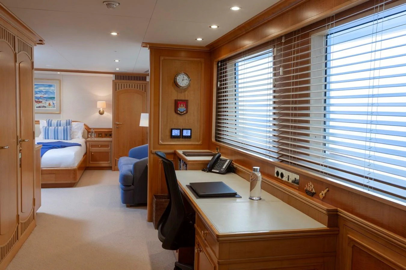 A luxurious stateroom featuring a comfortable workspace and a cozy bed area. aboard CONSTANCE Yacht for Sale