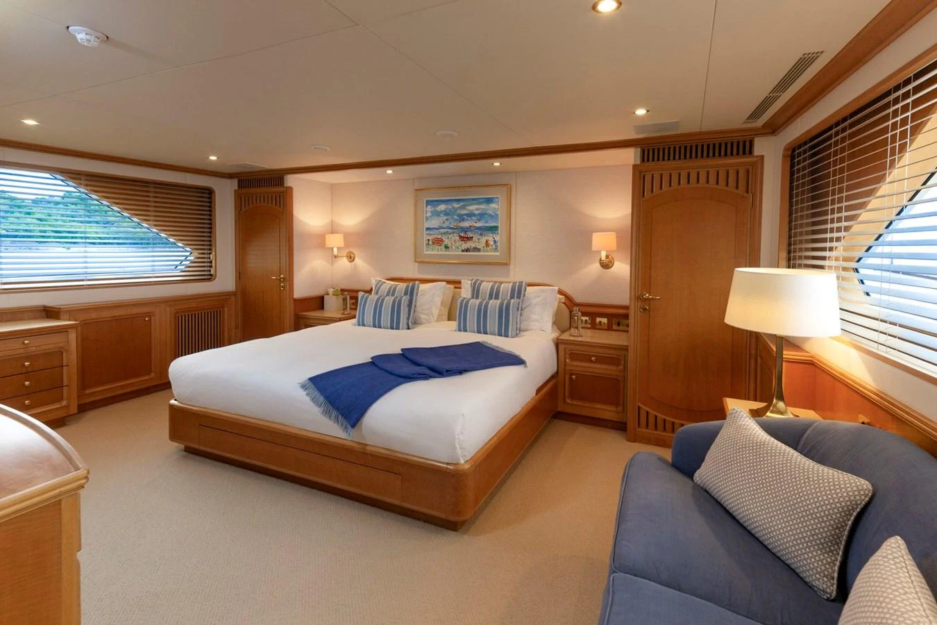 The master stateroom features a spacious bed with elegant wooden furnishings and ample natural light. aboard CONSTANCE Yacht for Sale