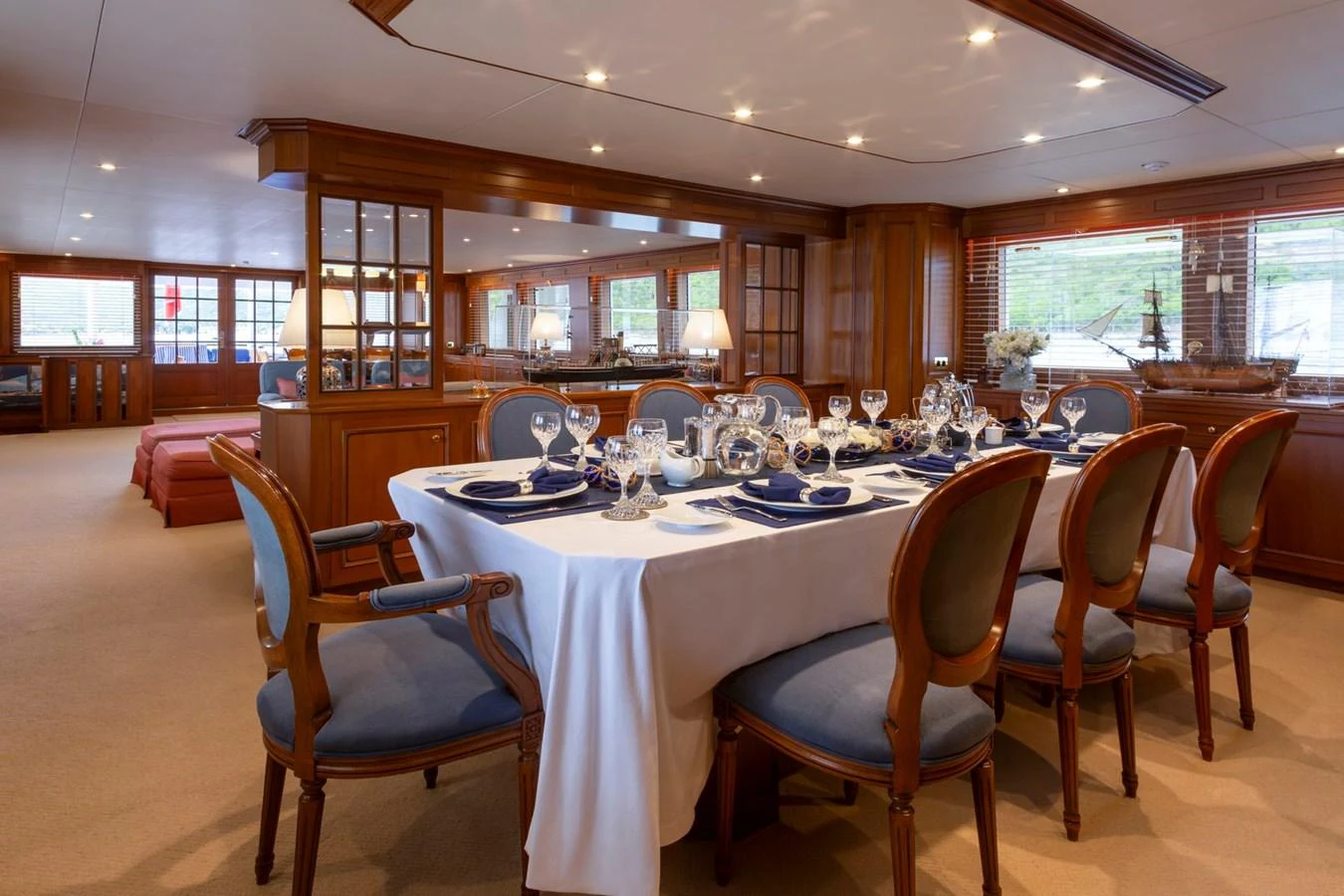 The yacht's dining area features an elegant table set for a fine dining experience, surrounded by plush seating and warm wooden accents. aboard CONSTANCE Yacht for Sale
