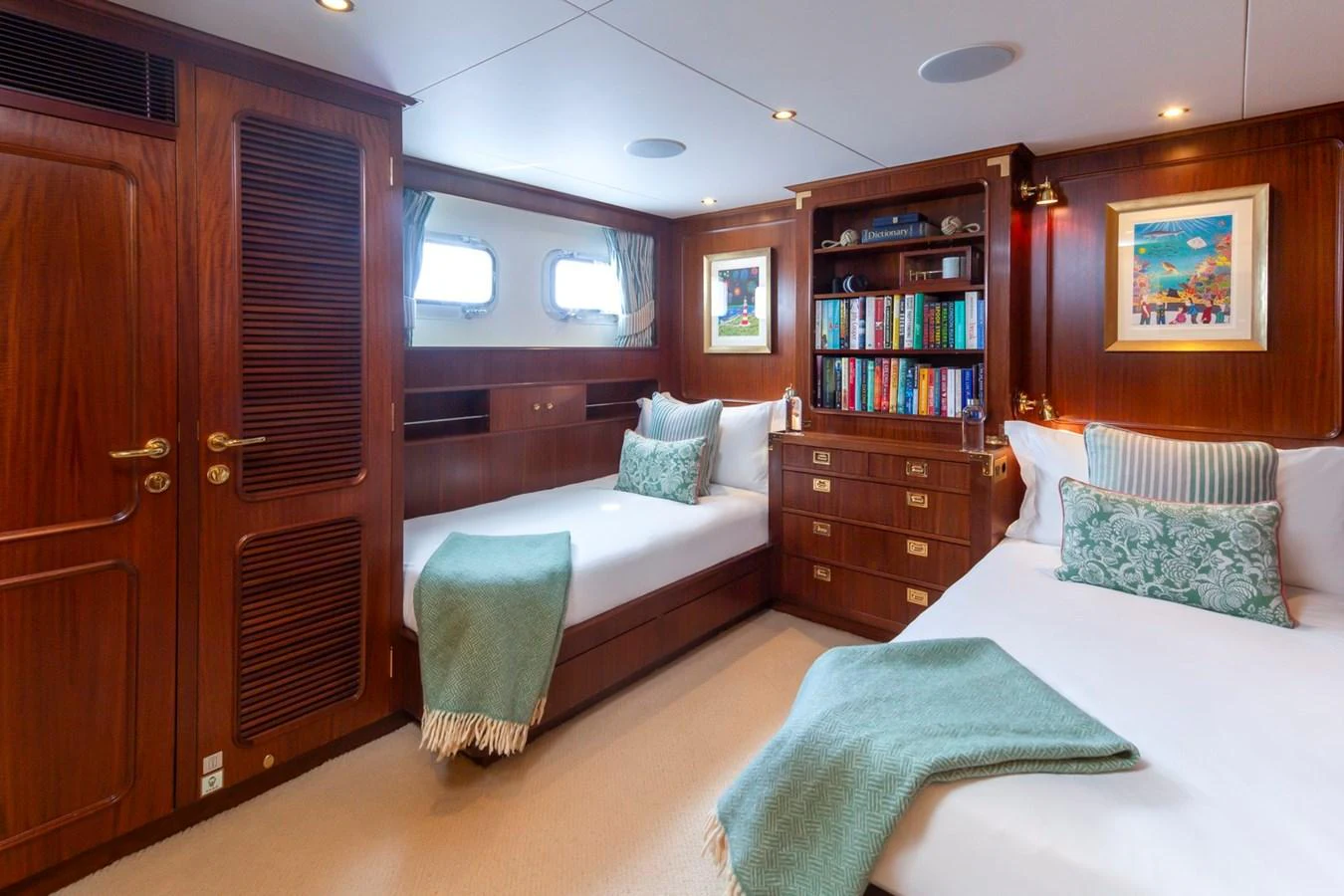 The guest stateroom features twin beds, warm wood paneling, and a cozy, inviting atmosphere. aboard CONSTANCE Yacht for Sale