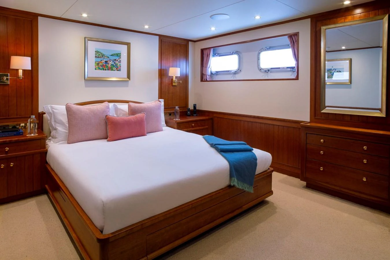 The stateroom features a comfortable bed with elegant wooden furnishings and soft lighting. aboard CONSTANCE Yacht for Sale
