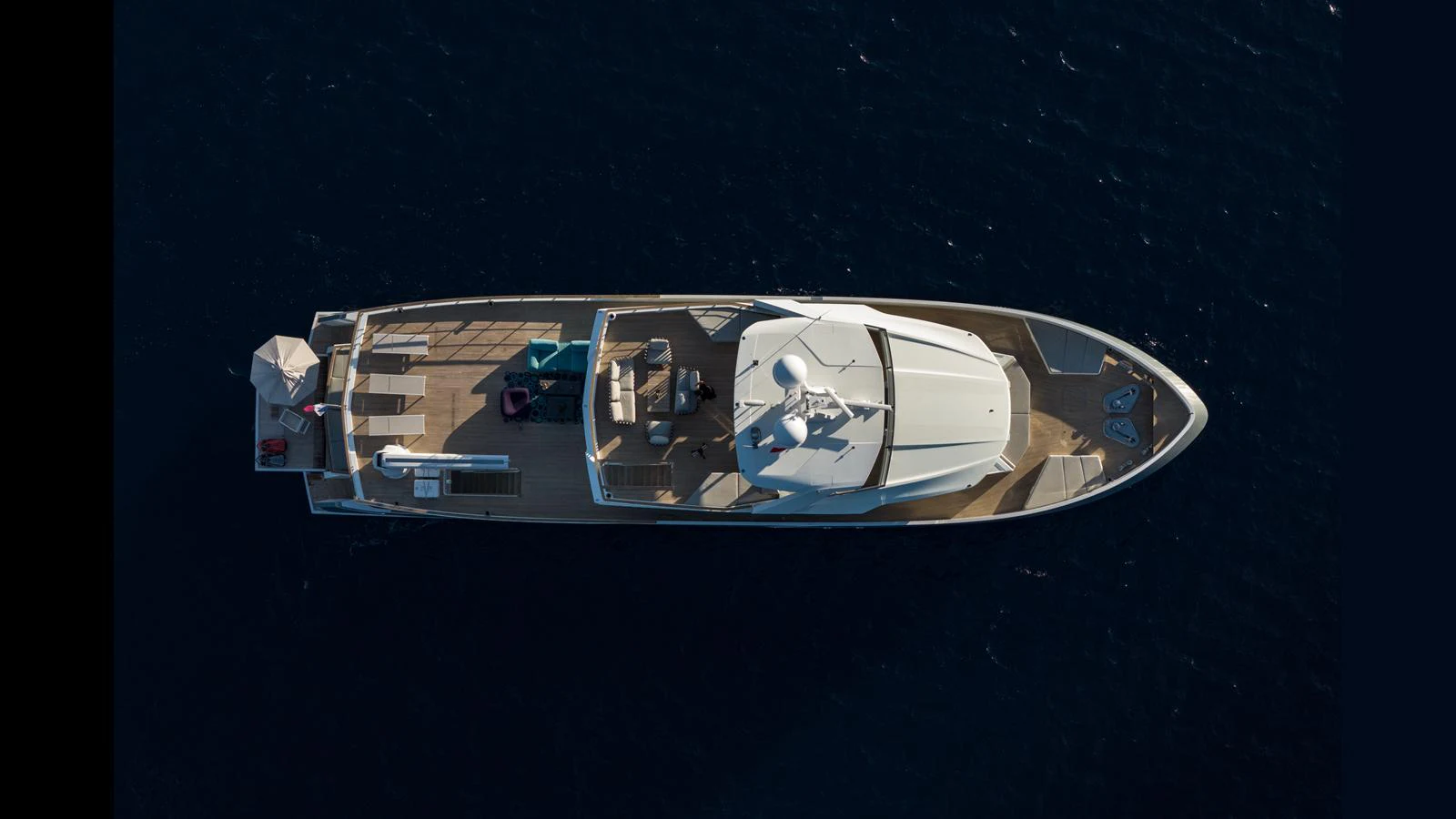 An aerial view of a sleek yacht cruising on deep blue waters. aboard Q.M Yacht for Sale