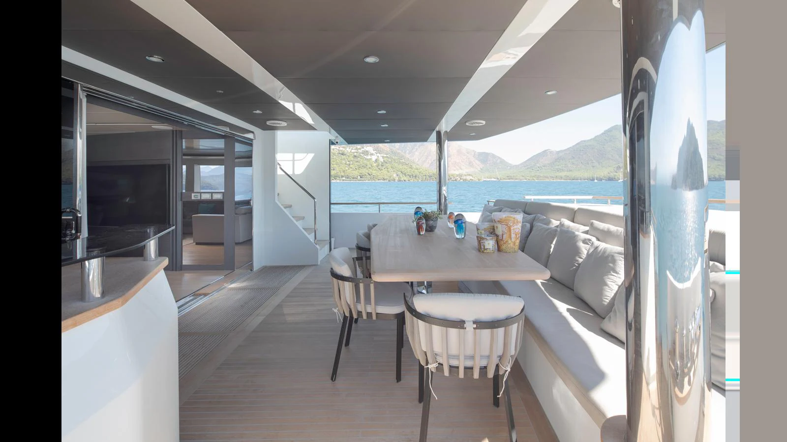 The aft deck features a spacious dining area with comfortable seating and scenic views. aboard Q.M Yacht for Sale