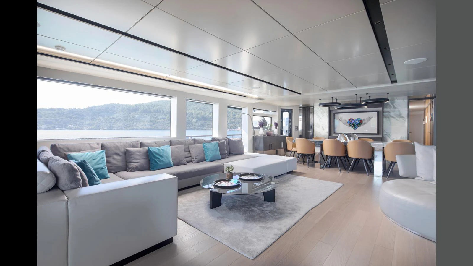 The spacious salon features modern furnishings with ample seating and panoramic windows. aboard Q.M Yacht for Sale