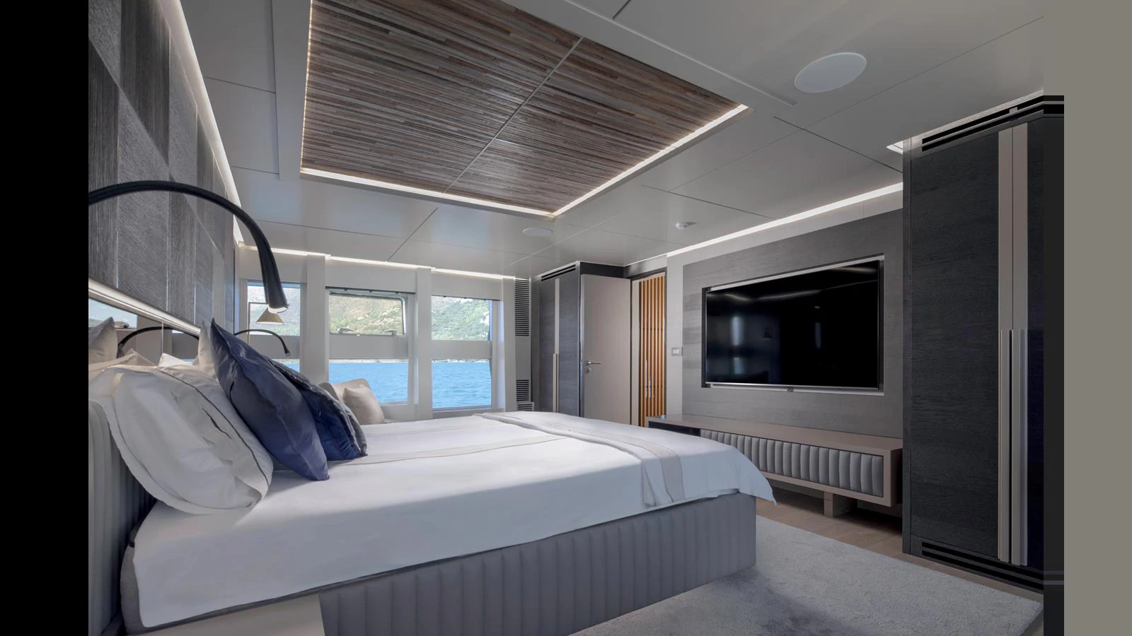 The master stateroom features a luxurious bed, modern decor, and a large flat-screen TV. aboard Q.M Yacht for Sale