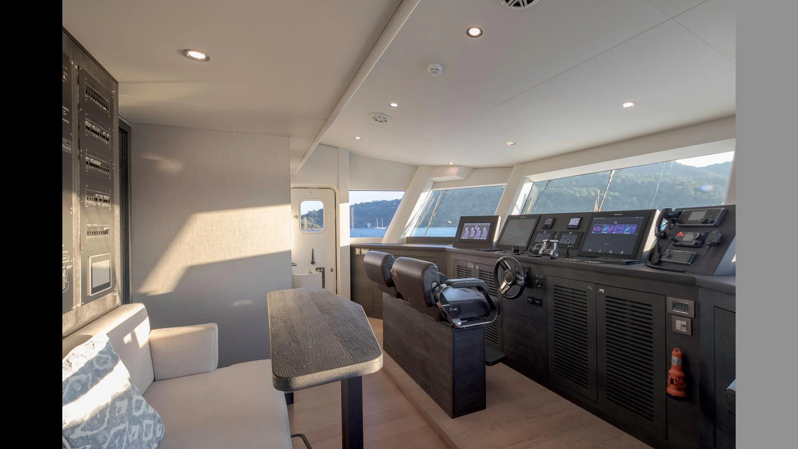 The helm area features modern navigation equipment and a comfortable seating arrangement with panoramic views. aboard Q.M Yacht for Sale