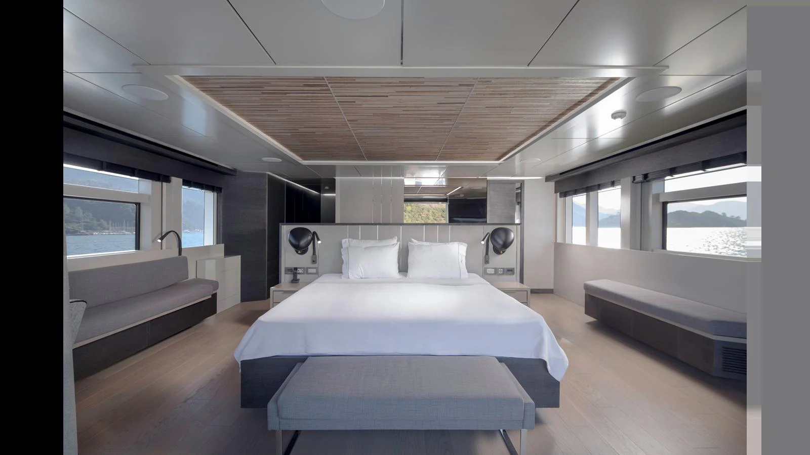 The master stateroom features a spacious bed with modern decor and ample natural light. aboard Q.M Yacht for Sale