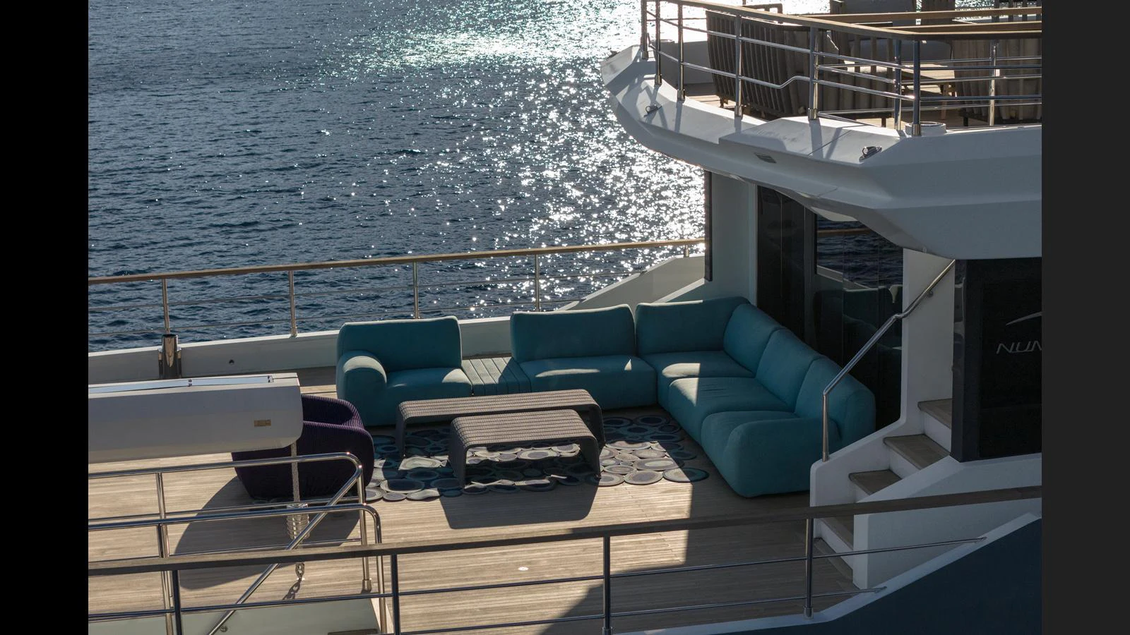 The yacht's aft deck features a stylish outdoor seating area with a stunning view of the water. aboard Q.M Yacht for Sale