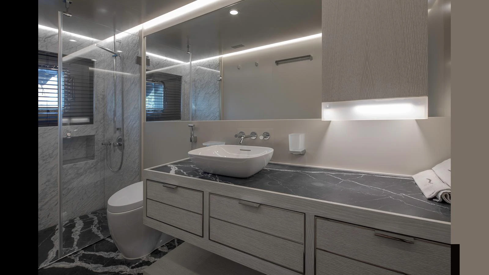 The yacht's bathroom features modern fixtures and a sleek design with a marble countertop and glass-enclosed shower. aboard Q.M Yacht for Sale