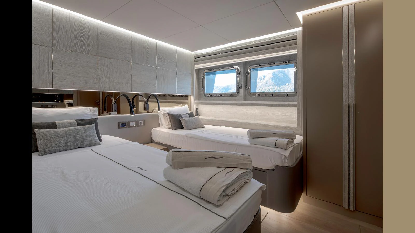 The guest stateroom features twin beds with modern decor and ample natural light from the windows. aboard Q.M Yacht for Sale
