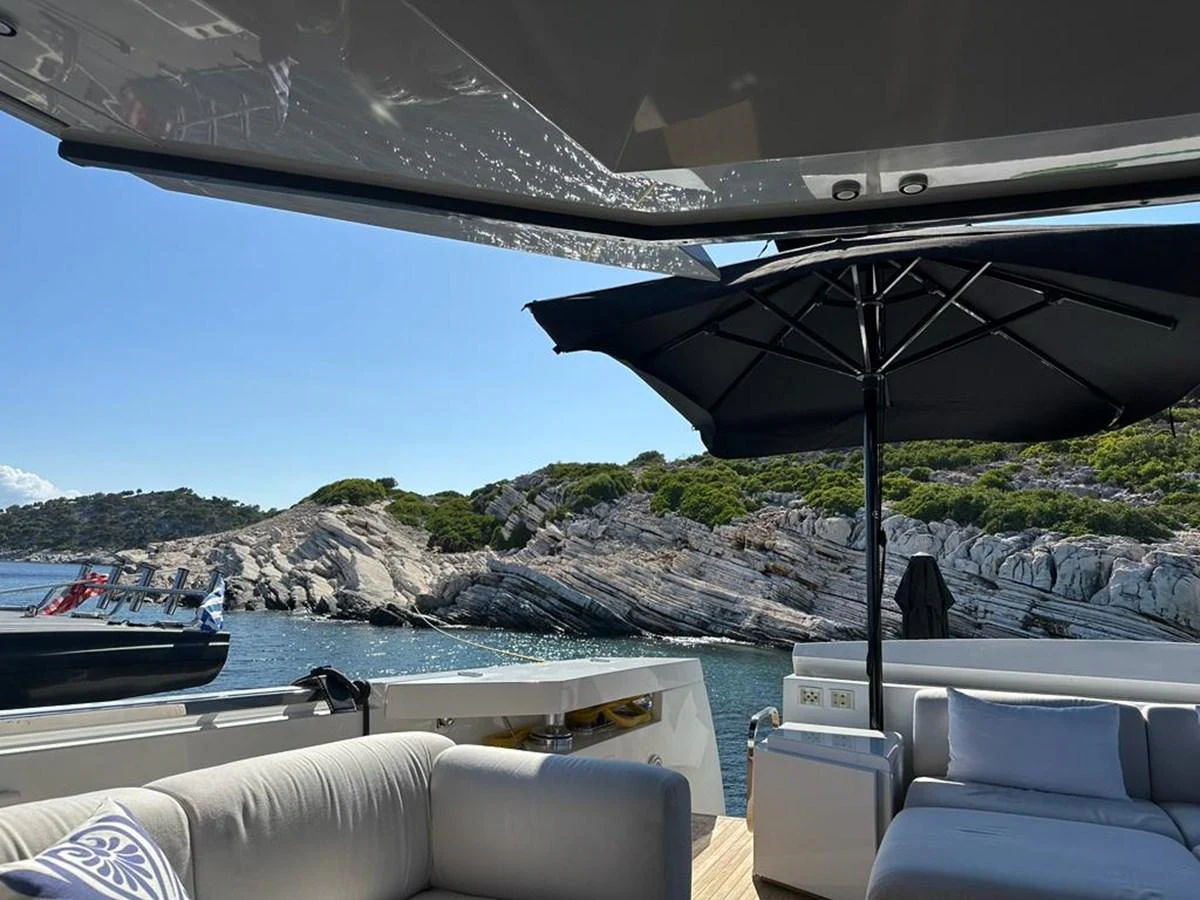 The aft deck offers a comfortable seating area with a view of the rocky shoreline. aboard D&D Yacht for Sale